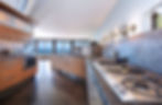 Modern kitchen with ocean view, wooden cabinets, and stainless steel appliances. Legourmet Kitchen