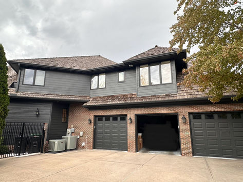 House with dark gray exterior paint and brick accents
