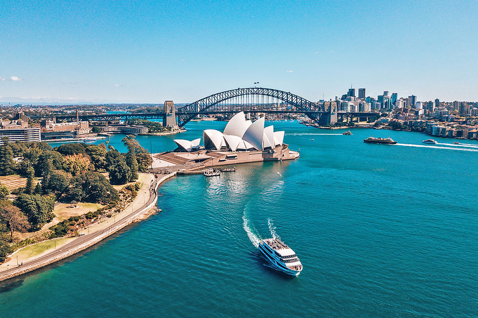 Sydney Opera House and Harbour Bridge in Sydney, Australia, over blue water.