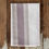 Thumbnail: Softly striped linen napkin in blush, taupe, and ivory tones folded on a rustic wooden surface.
