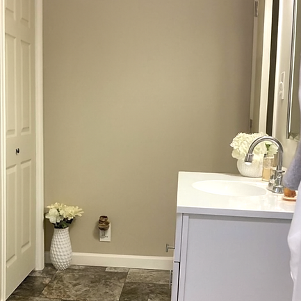 Bathroom with a white vanity, flowers, and a closed door, interior design space.