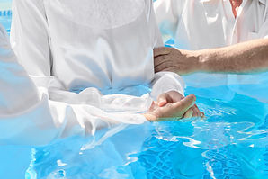 Two pastors baptize a women in the name of Christ.jpg