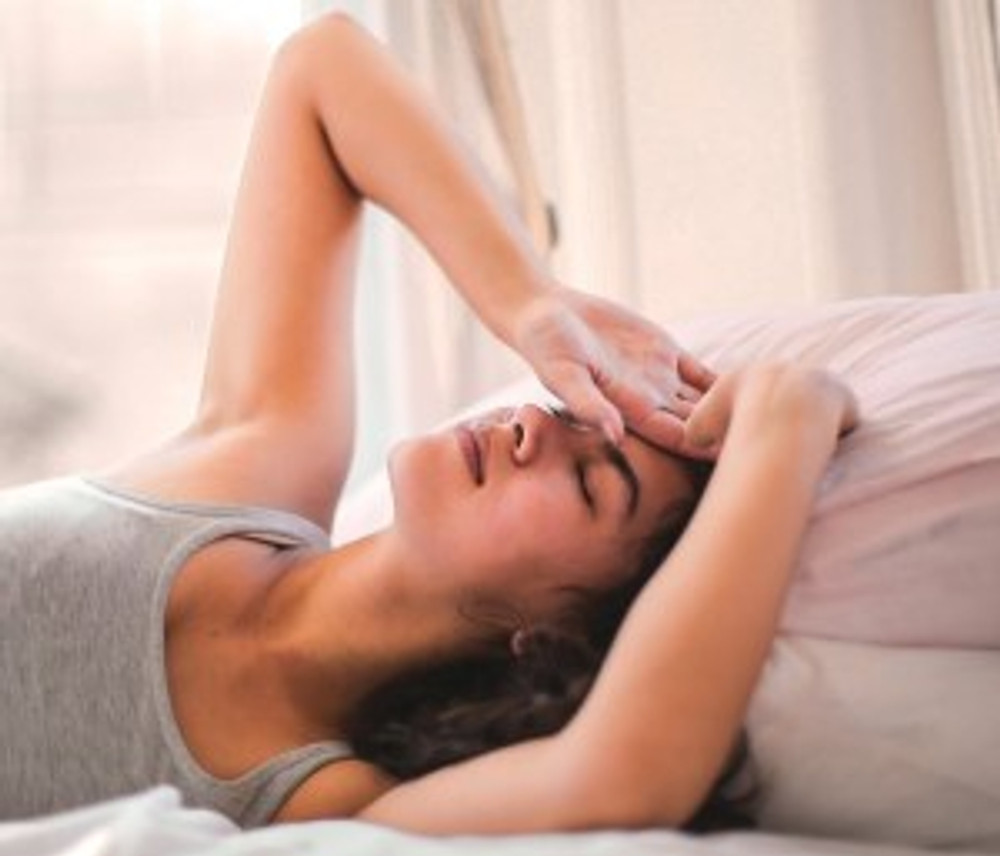 woman in gray tank top lying on bed