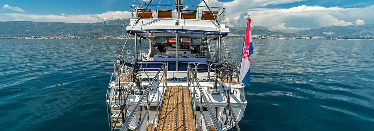 Maske gulet aft-deck cushioned seating area with wooden teak deck and sea view