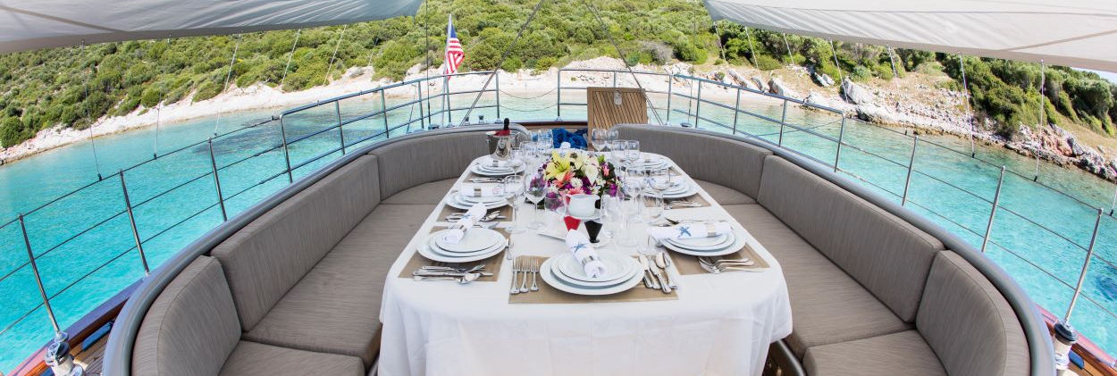 Le Pietre gulet aft-deck dining table under teak canopy