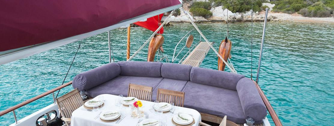 Primadonna gulet aft deck shaded dining table under bimini on teak deck