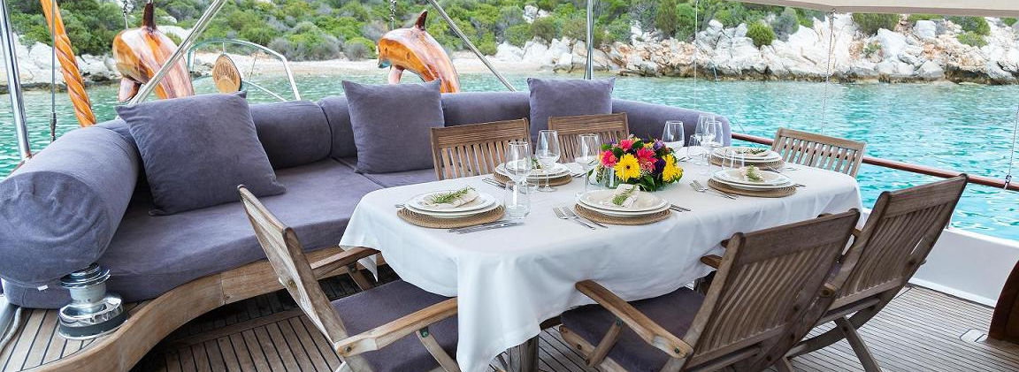 Primadonna gulet aft deck shaded dining table under bimini on teak deck