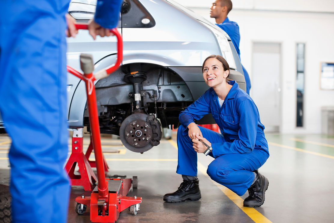 Mechanics working in auto repair shop with white van