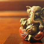 Create an energetic design of Lord Ganesha playing soccer with a green, blue, and white co