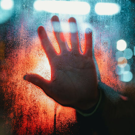 A hand pressing against a window. 