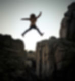 A person leaping over a crevace to represent bravery