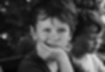 A young child looking into the camera, resting his chin on his hand to represent feeling fed up