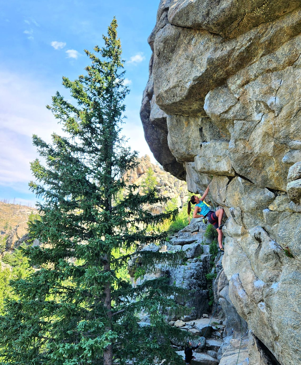 Woman rock climbing a steep cliff face