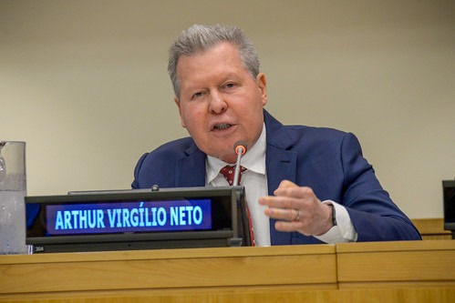 Arthur Virgílio Neto discursando atrás de uma placa com seu nome.
