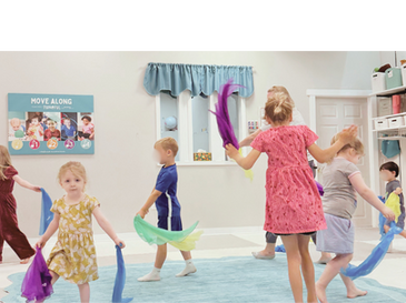 Young children moving with scarves in a Kindermusik class at Tuneful Journey.