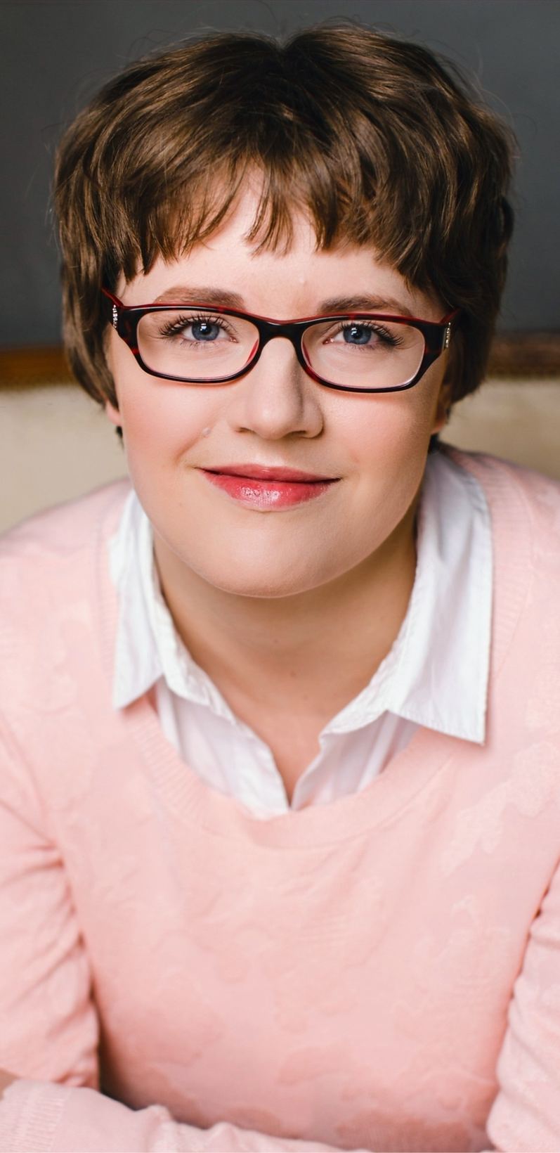 Headshot of Melissa smiling and wearing a pink sweater