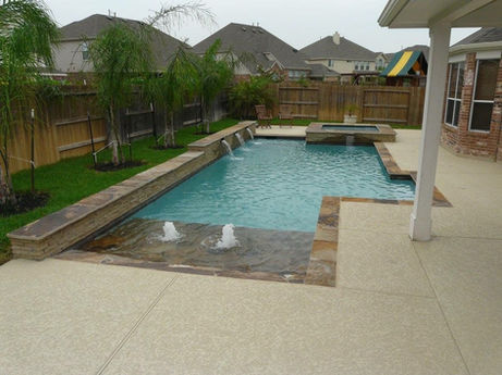 Backyard pool with waterfalls, fountains, and hot tub