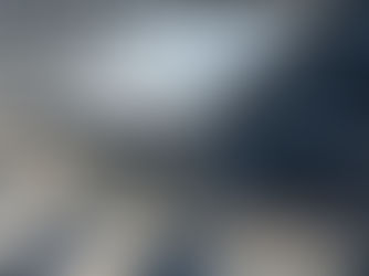 Skylight installed on a metallic roof, featuring screws and sealant. Sunlight casts shadows. Text partially visible on dark surface.