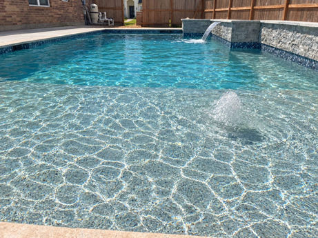 Rectangular pool with a shallow shelf and a raised stone wall spillway.