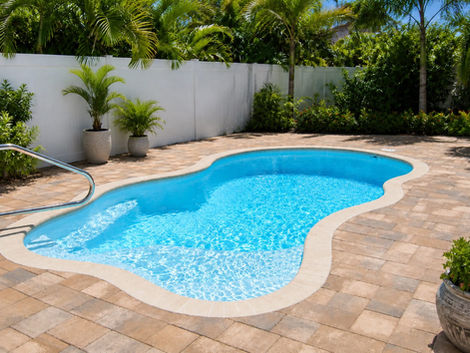 Kidney-shaped swimming pool with paver patio