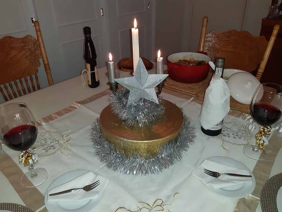 Our Epiphany dinner table laid out in white, gold and silver with a centre piece of three candles and the Star of Bethlehem.