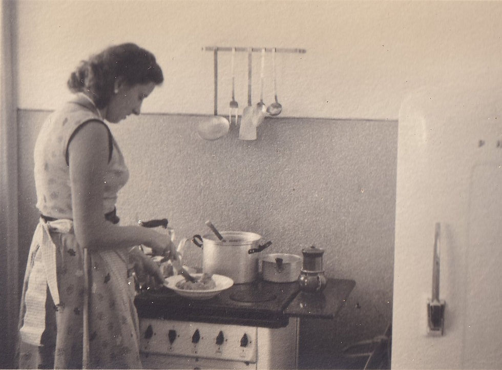 Sepia image of a woman cooking in her kitchen in the 1950s