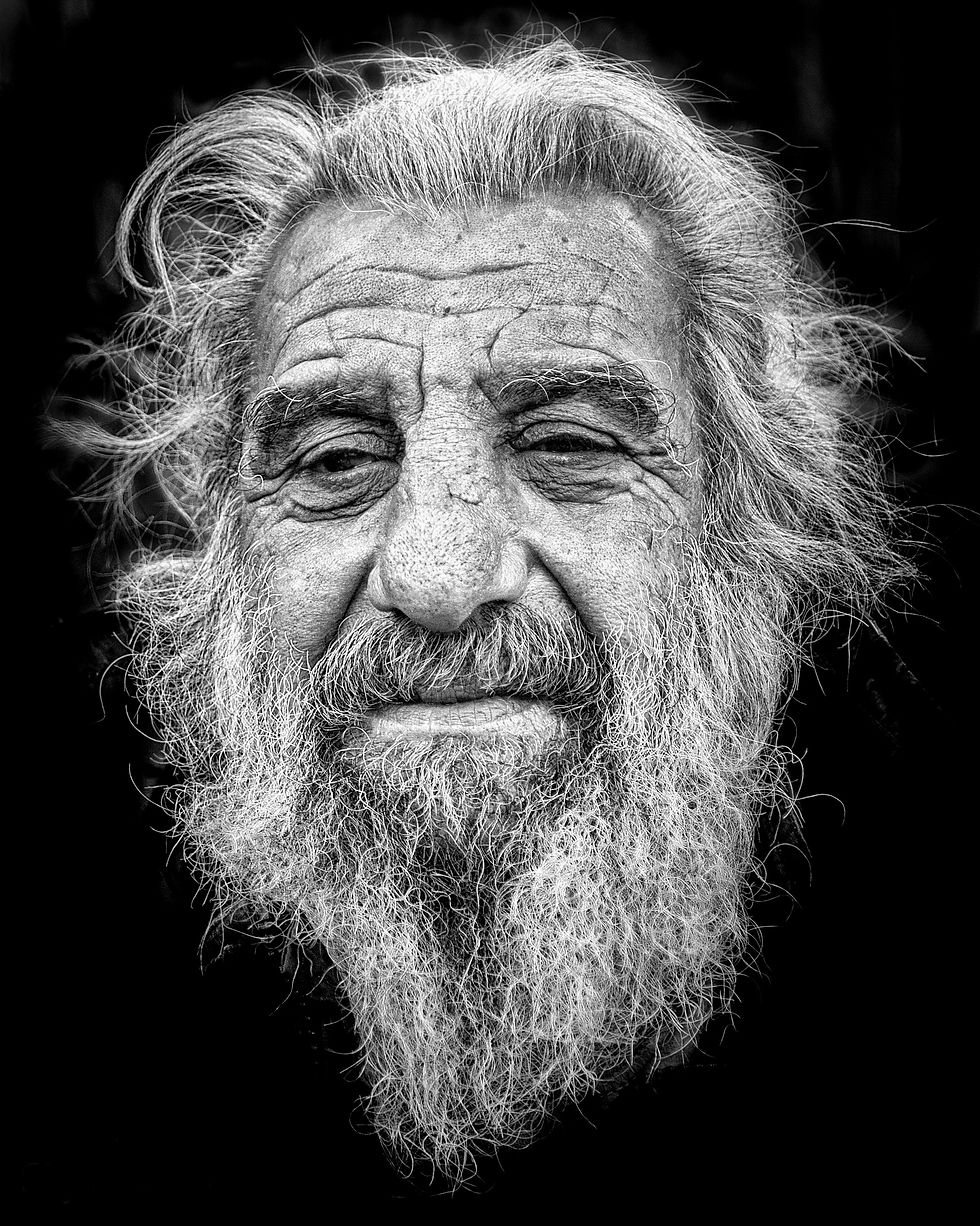 Black and white photo of an elderly man with grey hair and beard