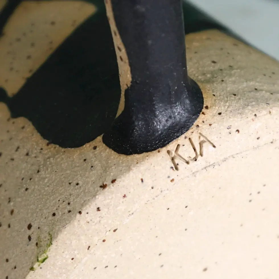 a piece of handwoven pottery with the artists mark.