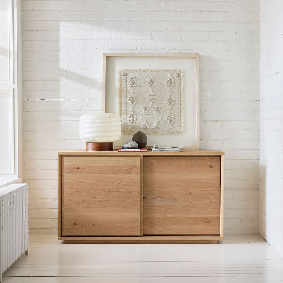 A framed neutral artisan textile on a white oak console