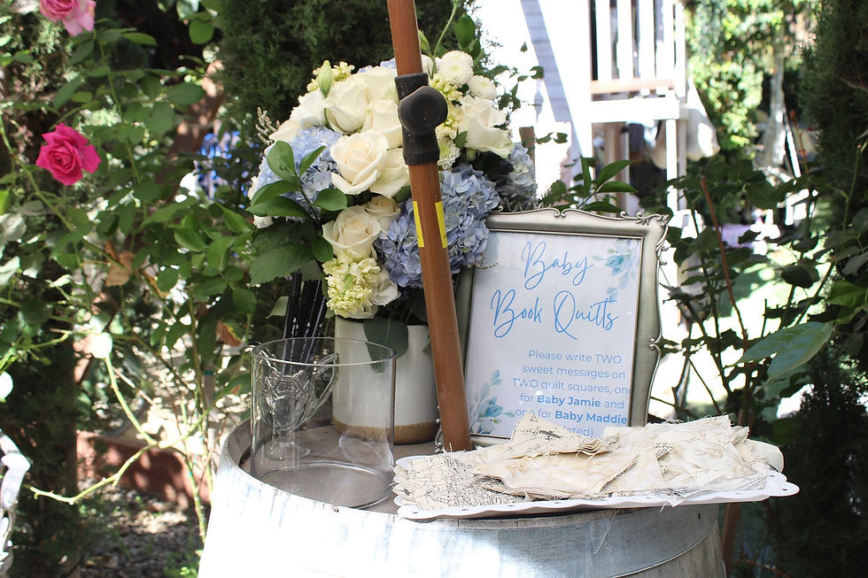 Baby shower guest book and keepsake activity arranged on a wine barrel in the garden