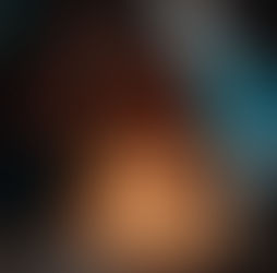 Fotograma de la película Niñas Escarlata. En un ambiente oscuro, una adolescente de piel morena y cabello rizado hasta los hombros está sentada frente a un pastel de cumpleaños blanco, mirando hacia abajo con expresión seria. Dos velas encendidas, con forma de los números «16», están clavadas en el pastel.