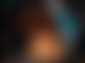 Fotograma de la película Niñas Escarlata. En un ambiente oscuro, una adolescente de piel morena y cabello rizado hasta los hombros está sentada frente a un pastel de cumpleaños blanco, mirando hacia abajo con expresión seria. Dos velas encendidas, con forma de los números «16», están clavadas en el pastel.