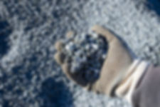 A hand holding Canadian Speckled Granite - 1/2" Clean showing the scale of the small angular rock