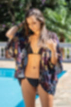 Uma modelo vestindo um biquíni preto e usando uma saída de praia do Studio Tangerina