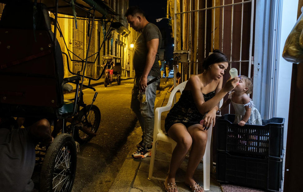 Documentary photograph of a young Cuban mother feeding her baby.