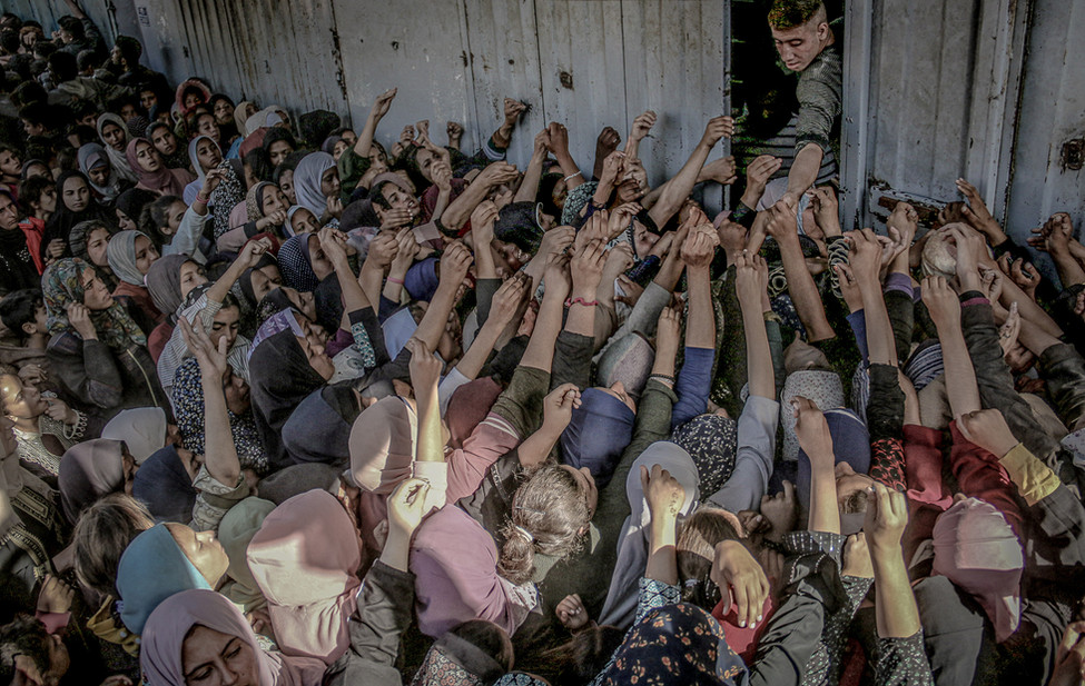 Photograph of Palestinians attempting to receive bread in Gaza.