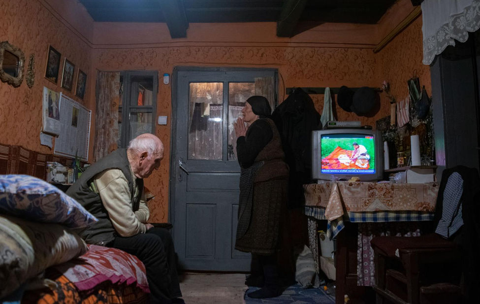 Documentary photograph of an elderly Romanian couple praying.