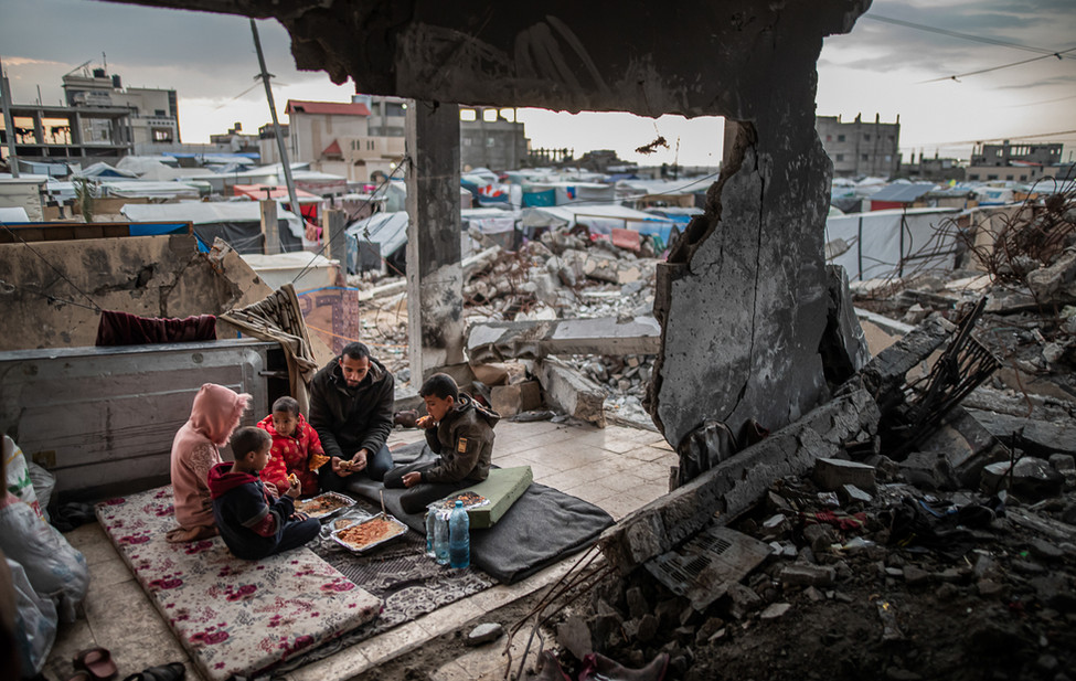 A Palestinian family in the rubble of a house destroyed in an Israeli attack in Rafah, Gaza.