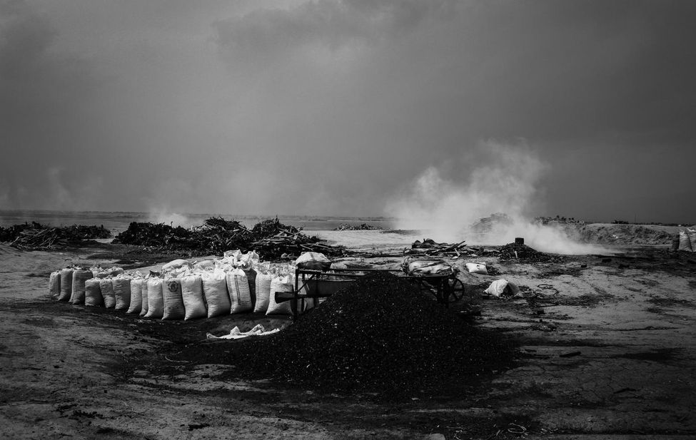 Documentary photograph of coal being passed through a sieve in Iran.
