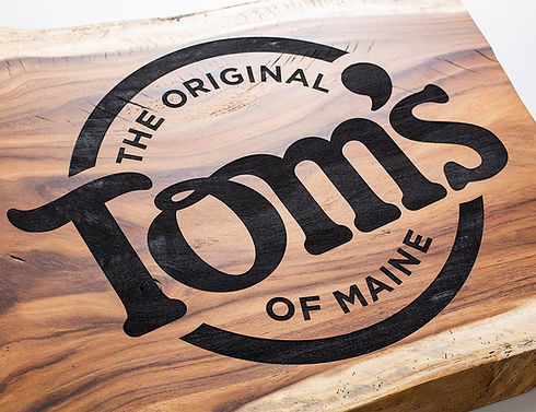 rustic live edge wood sign with Tom's engraved logo