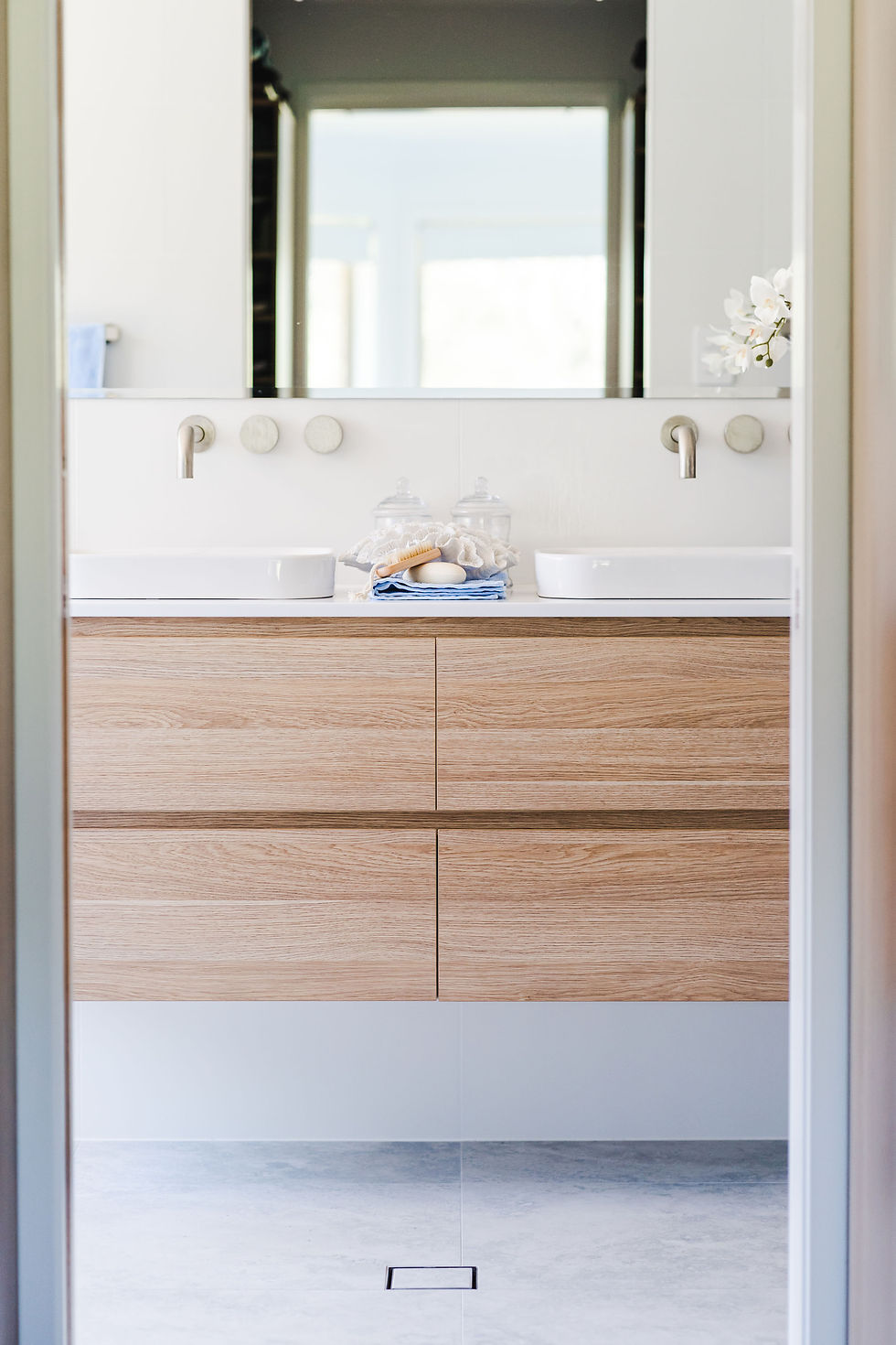 Island wall-hung vanity design with shower and toilet located behind