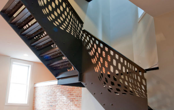 Gray steel stringer and guard rail with custom laser cut pattern and wood treads and handrail 