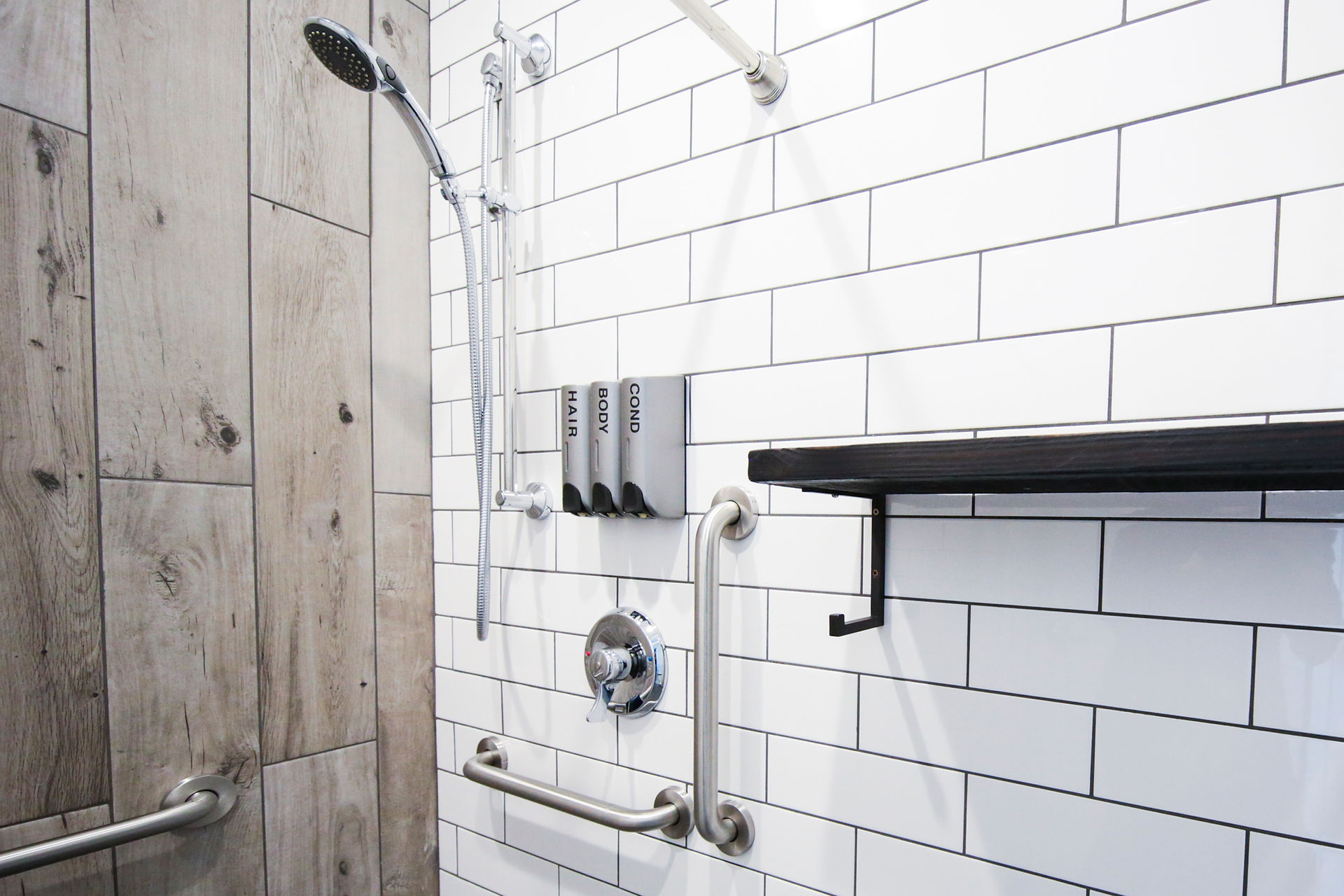 Shower interior with white subway tile and custom metal shelving