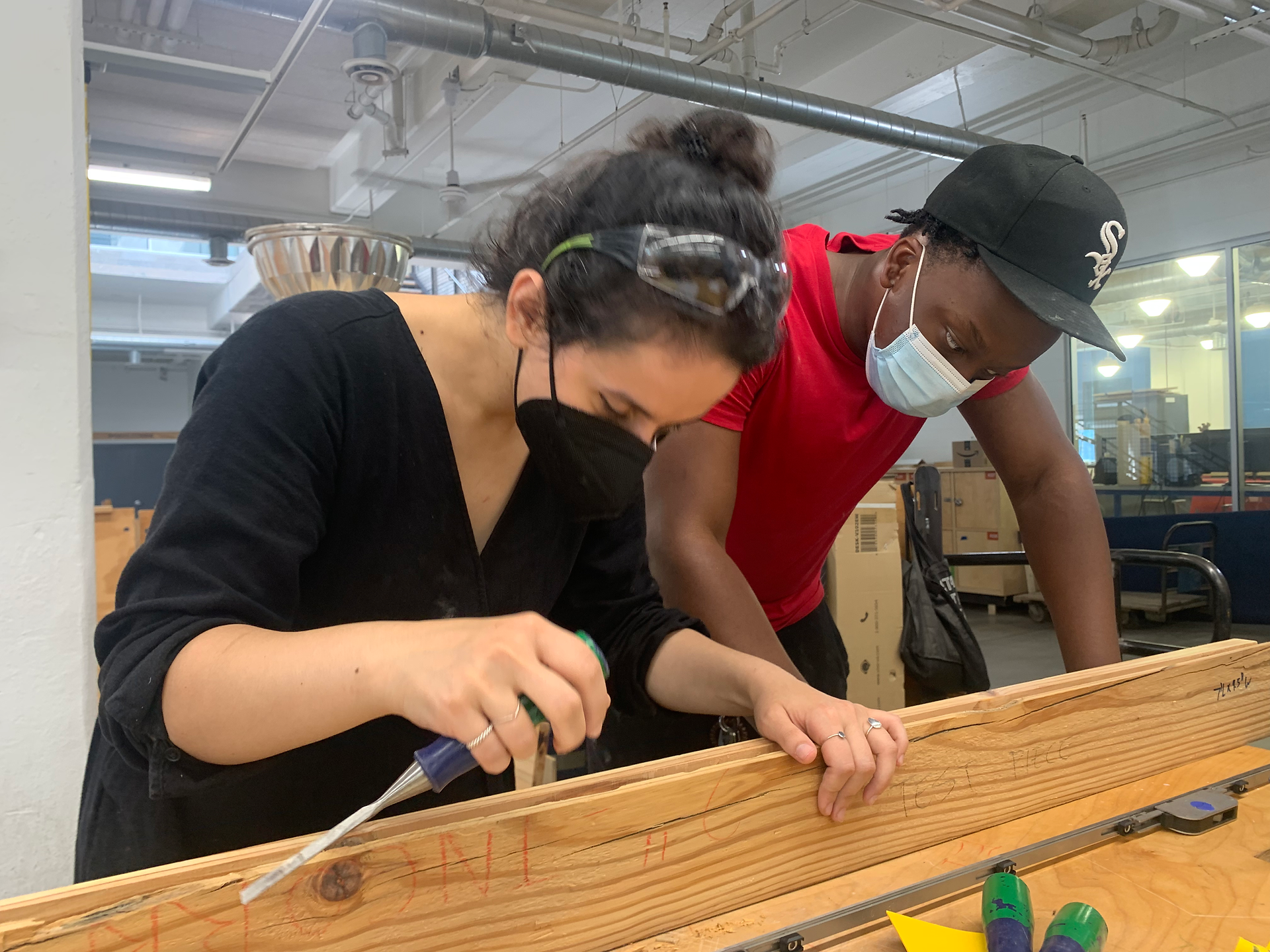 Teacher and student working on hand carving wood door jamb