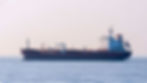 Tanker at sea in low visibility or at night — conveys the sense of a vessel operating without AIS. No need for explicit 'off AIS' labelling; visual ambiguity is appropriate.