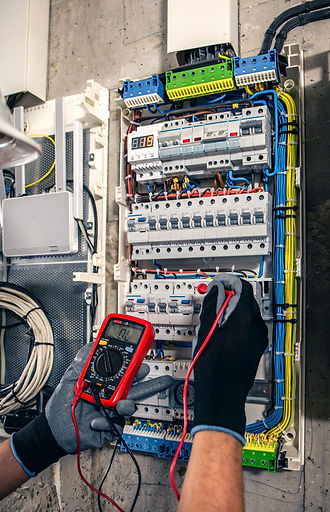 Elektrikçi, ölçüm cihazı ile elektrik panosunu kontrol ediyor. Yalçınkaya Elektrik Tesisatı Döşeme