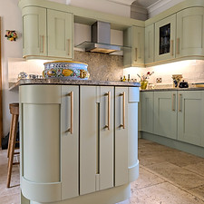 Refined kitchen featuring painted cabinetry, brass handles and a handcrafted tiled splashback.