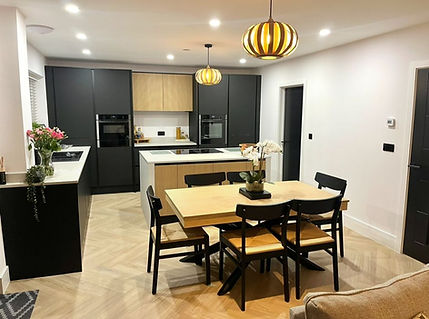 Kitchen before refinishing with dark black cabinets and dining area in Merthyr Tydfil