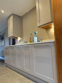 Original Shaker kitchen cabinets with a light painted finish, silver handles and pale worktops, photographed before the cabinetry refinishing project.