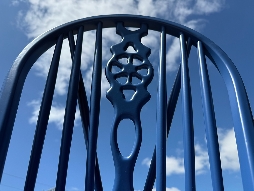 Spray-finished spindle chair back with curved top rail and central detail, showing smooth, even coating across complex shapes